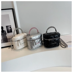 Tre mini borse trapuntate con catena in beige, argento e nero su sfondo minimalista