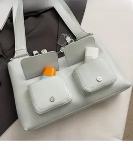 Detail of mint green tote bag featuring two front utility pockets and silver magnetic buckles