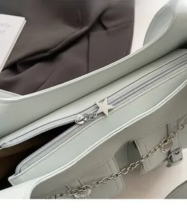 Close-up of smooth silver zipper with star pendant and chain on mint green tote bag