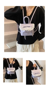 Detalle de mini mochila lavanda con encaje blanco y lazo en una escalera