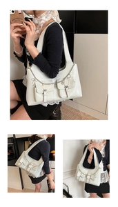 Macro detail of white oil wax leather tote with double pockets and heart chain