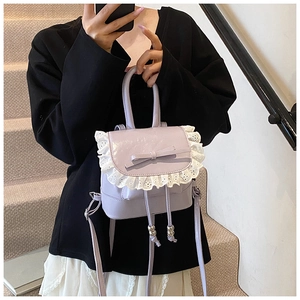 Detail of lavender mini backpack featuring bow decoration and delicate white lace trim