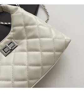Détail d'un sac en cuir matelassé crème avec fermoir en métal argenté et bandoulière