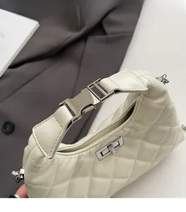Détails de la boucle métallique argentée et cuir blanc matelassé du sac à bandoulière