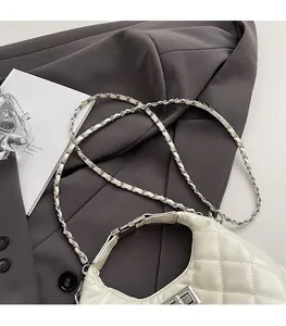 Détail du sac demi-lune en cuir matelassé beige avec bandoulière chaîne et losanges