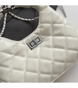 Vue détaillée du fermoir pivotant en métal argenté et surpiqûres du sac hobo blanc