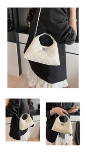Détail d'un sac à main matelassé beige avec surpiqûres en losange et fermoir argenté