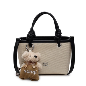 Minimalist woven straw bucket bag with black leather handles and cute plush bear charm
