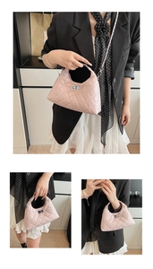 Détail du sac matelassé rose avec fermoir rotatif argenté et bandoulière en chaîne métal