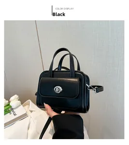 Dettaglio di una borsa a mano nera in pelle con chiusura girevole argento in mano