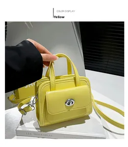 Dettaglio della borsa gialla in pelle PU con chiusura a scatto in metallo e manico