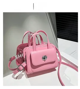 Dettaglio di una borsa quadrata rosa con chiusura a scatto in argento e pelle sintetica liscia