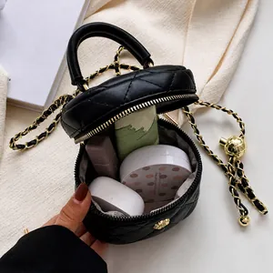 Interior view of black quilted round bag showing capacity for lipstick and cushion