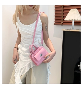 Borsa a tracolla rosa minimalista con chiusura girevole argento in un contesto casual