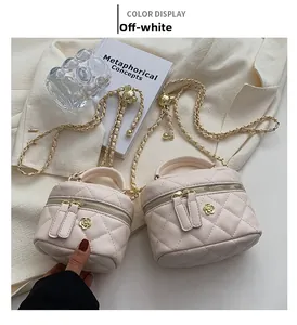 Detail of off-white quilted mini box bag with gold chain and floral hardware