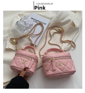 Detail of pink quilted mini box bag featuring golden flower clasp and woven chain strap