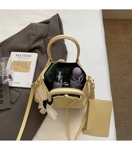 Close-up of cream woven bucket bag showing large capacity with phone and umbrella