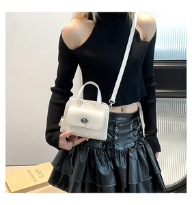 Elegante borsa beige con chiusura metallica argento e tracolla rimovibile sul modello