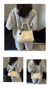 Detail showing cream woven leather texture, top handle, and elegant flower charm pendant