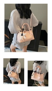 Detail of light pink woven leather tote featuring metal rings and a sunflower charm