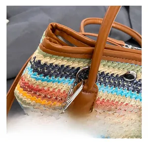 Détail d'un sac en paille tressée colorée avec crochet pivotant en métal argenté et finitions