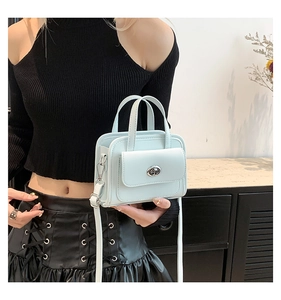 Dettaglio mini borsa squadrata azzurra con chiusura a scatto argento e tracolla sottile