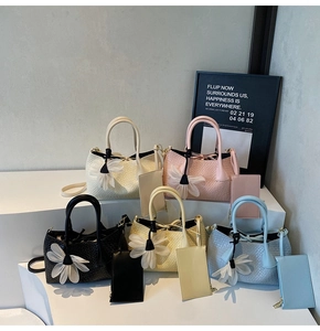 Group display of woven texture tote bags in five colors with matching pouches and charms