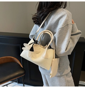 Detail of cream white woven bucket bag with large mesh flower charm and small pouch
