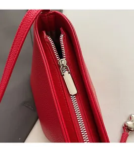 Close-up of bright red lychee texture leather bucket bag with silver metal zipper detail