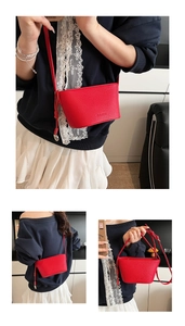 Detail view of red lychee pattern leather bucket bag with brand logo and crossbody strap