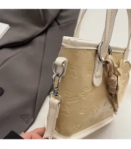 Détail du sac cabas en cuir blanc avec gaufrage chien et papillon et ferrures argent