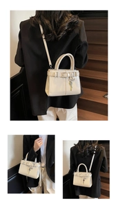 Détail du sac bandoulière crème avec lanière en cuir et breloque clé en métal décorative