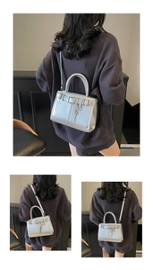 Vue détaillée du petit sac carré argenté avec boucle de ceinture et pendentif clé chic