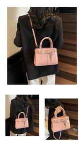 Détail du sac à main rose clair brillant avec sangle à boucle et porte-clés métallique