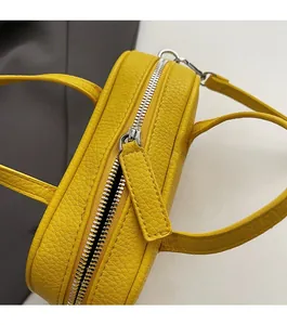Detail of yellow lychee pattern leather with a smooth silver metal zipper and soft texture