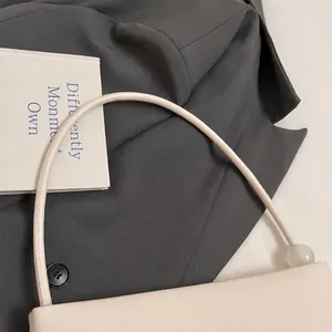 Detailed shot of comfortable beige leather handbag handle with sleek round bead hardware