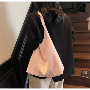 Close-up of pink large capacity leather tote bag worn by model on shoulder
