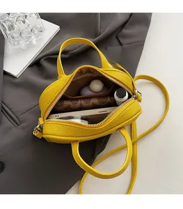 Top view of open yellow cross-body bag showing spacious interior for essentials
