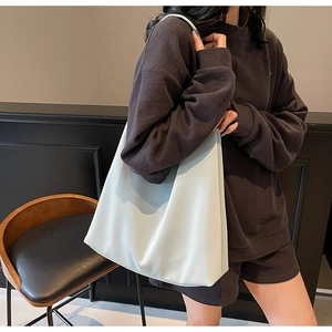 Detail of mint green oversized tote bag showing soft synthetic leather texture and strap