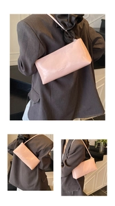 Detail view of pink patent leather baguette bag with minimalist embossed logo on the side