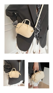 Detail of cream white lychee texture leather mini bag with smiley face pendant
