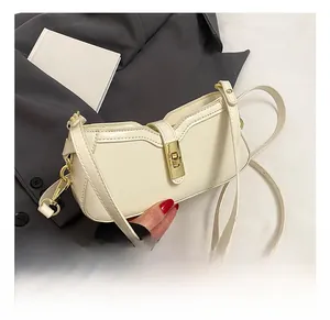 Détail du sac baguette en similicuir blanc cassé avec boucle dorée sur un blazer gris
