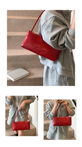 Detailed close-up of a red glossy leather baguette bag with minimalist embossed texture