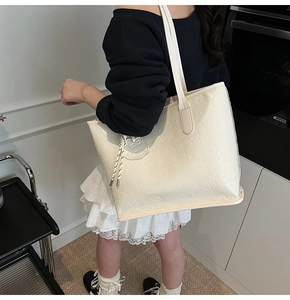 Détail du sac fourre-tout crème en similicuir avec motifs de dessins animés embossés