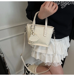 Détail du sac fourre-tout blanc crème avec relief de chien cartoon et charme assorti