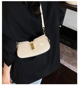 Détail du sac à bandoulière en cuir verni crème avec un fermoir mécanique doré élégant