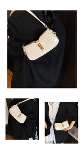 Détail d'un sac sous le bras en cuir verni crème avec boucle dorée sur les vêtements