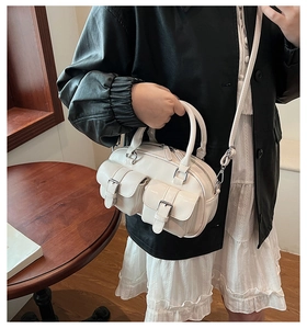 Sac à main blanc verni avec deux poches avant et boucles argentées élégantes