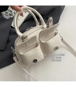 Vue détaillée du sac Boston en cuir ciré blanc avec deux poches avant à rabat aimanté