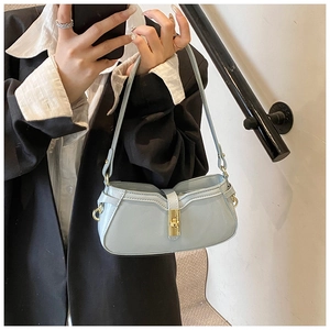 Détail du sac sous le bras en similicuir bleu clair avec fermoir rotatif doré en métal